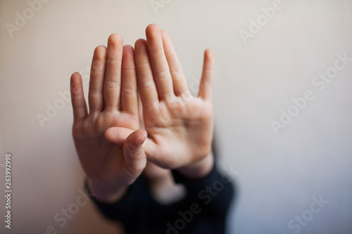 Little girl protects herself with her hand