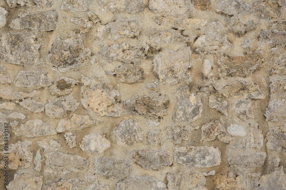 Old beige stone wall background texture close up Old beige stone wall background texture close up