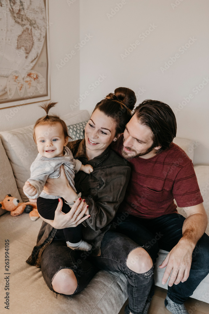 Happy family with baby girl in living room at home