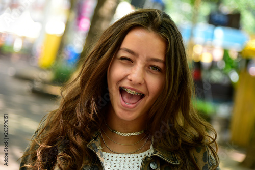 Portrait of winking teenage girl wearing braces photo