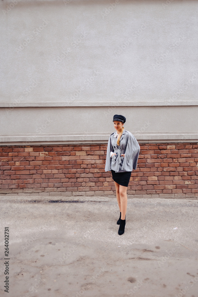 A cute, pretty girl in a stylish suit walks around the city and poses A cute, pretty girl in a stylish suit walks around the city and poses