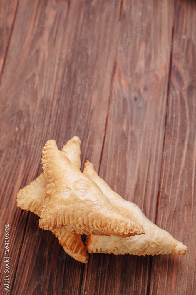 fresh triangular pastry on a wooden background fresh triangular pastry on a wooden background