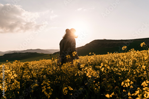 Unrecognizable woman walking among flowers photo