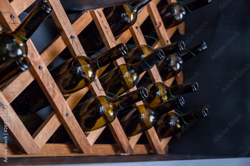 Fototapeta premium empty bottles decorative on the shelfs.interior decorative elements.decorative wall. creative interior design of the bar, restaurant, hotel. Abstract decorative design.Glass bottles in wooden boxes