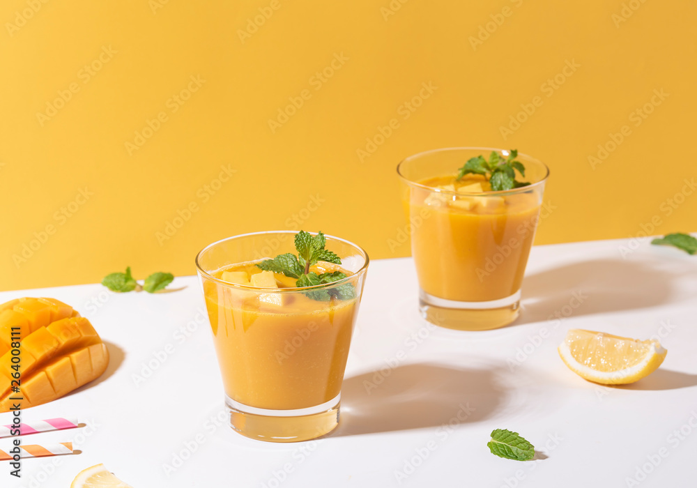 Fresh mango smoothie and ripe mango slice on color background. summer drink. Fresh mango smoothie and ripe mango slice on color background. summer drink.