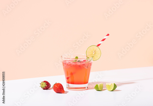 iced strawberry punch cocktail in glass with lemon on color background. summer drink. photo