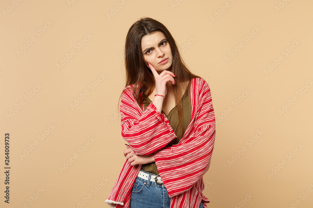 Portrait of pensive young woman in casual clothes looking camera put hand prop up on chin isolated on pastel beige background in studio. People sincere emotions, lifestyle concept. Mock up copy space. Portrait of pensive young woman in casual clothes looking camera put hand prop up on chin isolated on pastel beige background in studio. People sincere emotions, lifestyle concept. Mock up copy space.