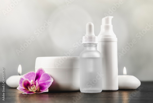 Various beauty products containers on table with blurred bokeh background, copy space. Artistic colors.