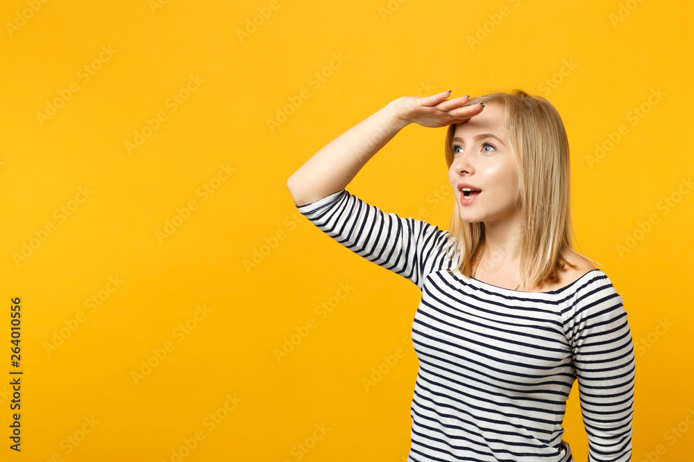 Amazed young woman in striped clothes holding hand at forehead looking aside far away†distance isolated on yellow orange wall background. People sincere emotions lifestyle concept. Mock up copy space. Amazed young woman in striped clothes holding hand at forehead looking aside far away†distance isolated on yellow orange wall background. People sincere emotions lifestyle concept. Mock up copy space.
