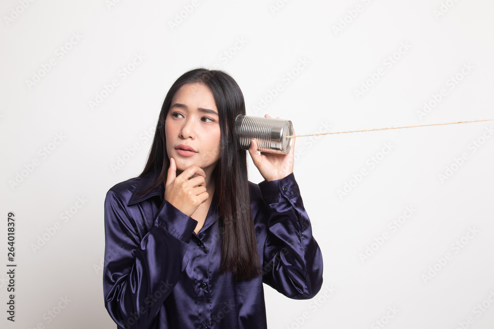 Young Asian woman hearing with tin can phone and thinking. Young Asian woman hearing with tin can phone and thinking.