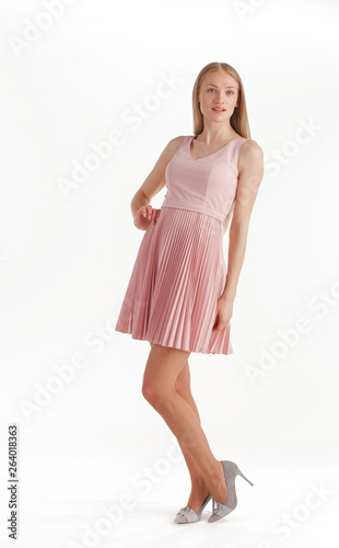 Beautiful young blonde woman in pink dress isolated on white background
