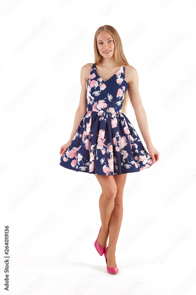 Beautiful young blonde woman in dark blue dress with floral print isolated on white background Beautiful young blonde woman in dark blue dress with floral print isolated on white background