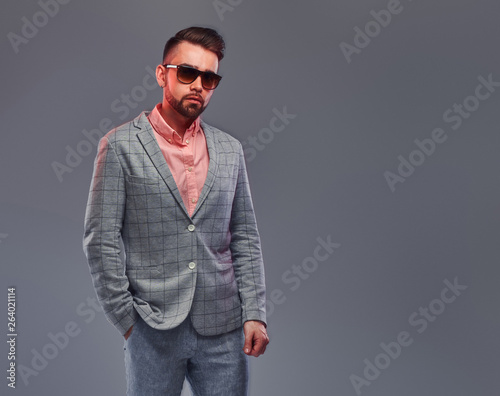 Portrait of styilish serious man in checkered blazer, sunglasses and pink shirt.  © Fxquadro