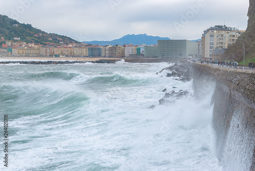 Sea waves over the pedestrian walkway in Donostia - San Sebastian, Spain