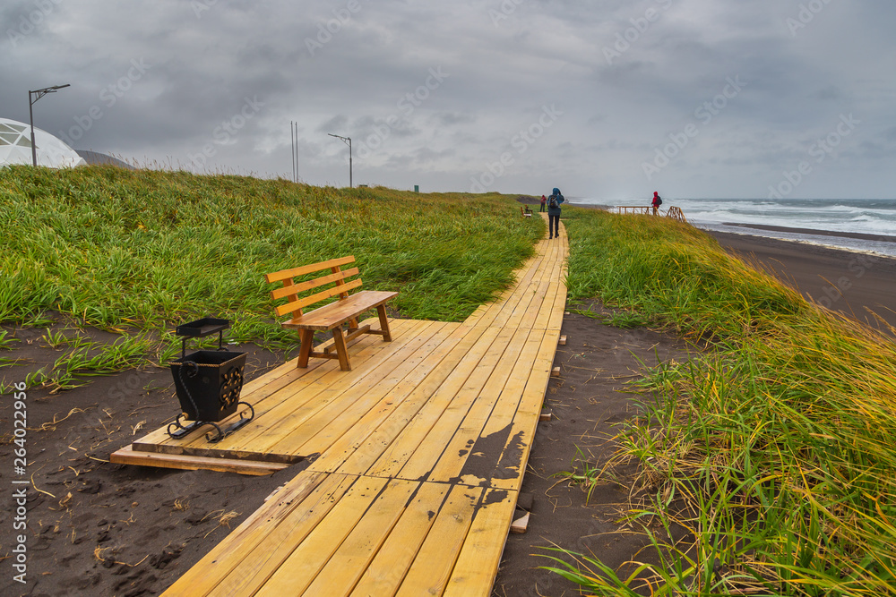 Φωτογραφία Wooden footbridges and benches along the volcanic beach, Kamchatka, Russia