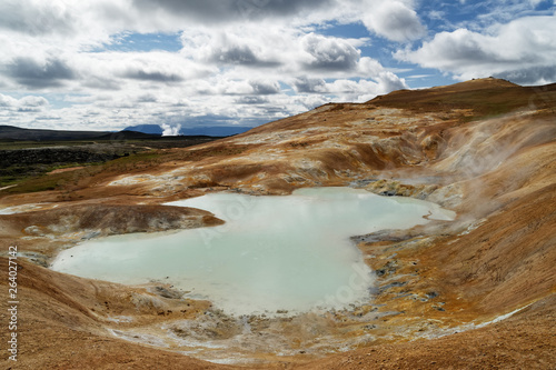 Wide volcanic landscape, a pond filled with thermal water and sulfur springs, rising steam and lava fields in the background, above it a sky with clouds - Iceland, Krafla Lava Fields, Leirhnjukur
