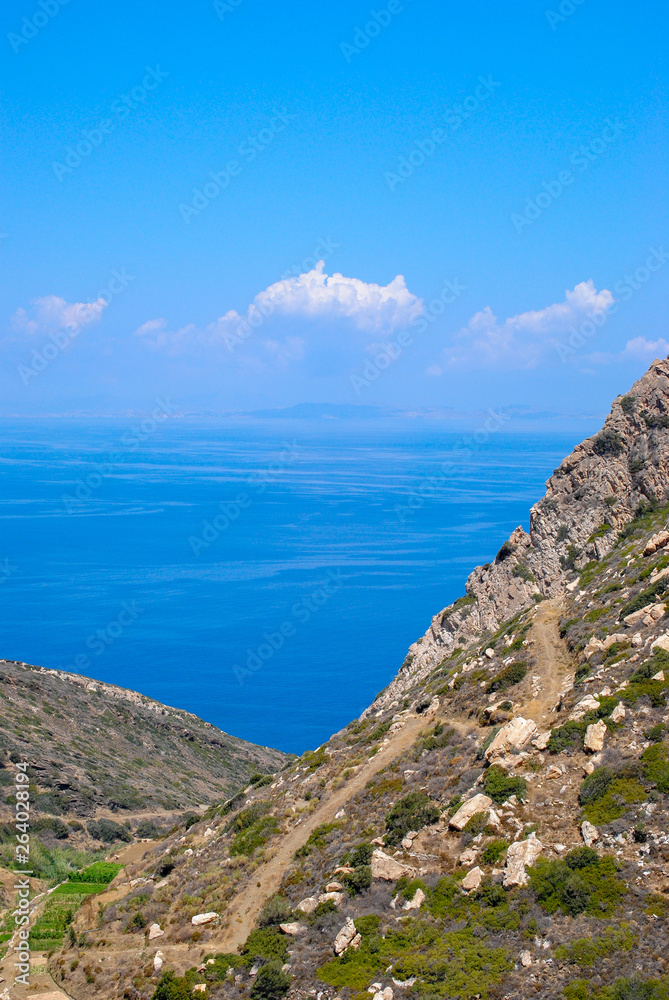 greek landscape in naxos with meadow, mountain and blue sky.