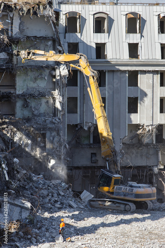 Building of the former hotel demolition for new construction, using a special hydraulic excavator-destroyer. Complete highly mechanized demolition of building structures. Construction site 