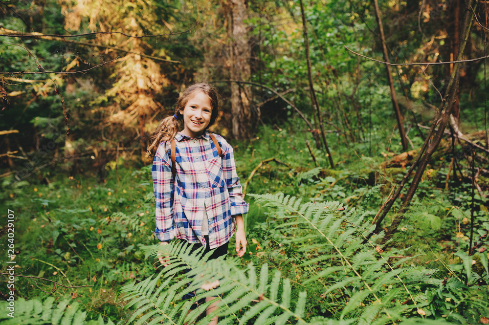 happy kid girl exploring summer forest, traveling on vacation. Teaching kids to love nature. Earth day concept.