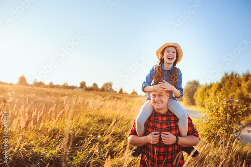 happy father and daughter walking on summer meadow, having fun and playing. Father's day, fatherhood concept. Rural living.