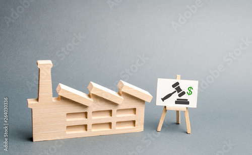 Figure factory and stand with the image of the auction. Privatization of state-owned factories and plants. Property sale through auction, bankruptcy and liquidation of enterprises. Tender construction photo