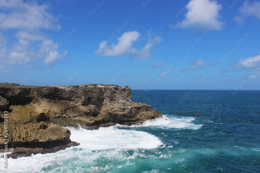 Landscape rock boulder in the middle of ocean with sea foam crashing