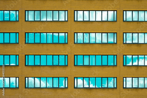 Yellow brick wall with windows. Facade of office building with windows. Facade of an old yellow brick wall with windows.