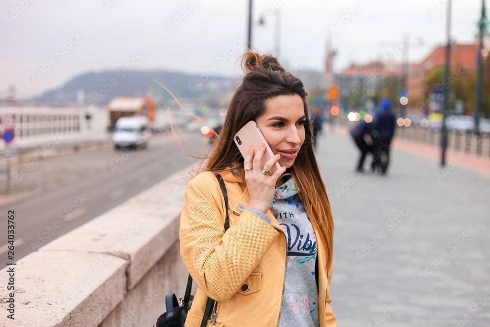 young beauty girl talk on phone on Budapest parliament background 