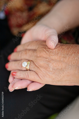 2 senior women hold hands