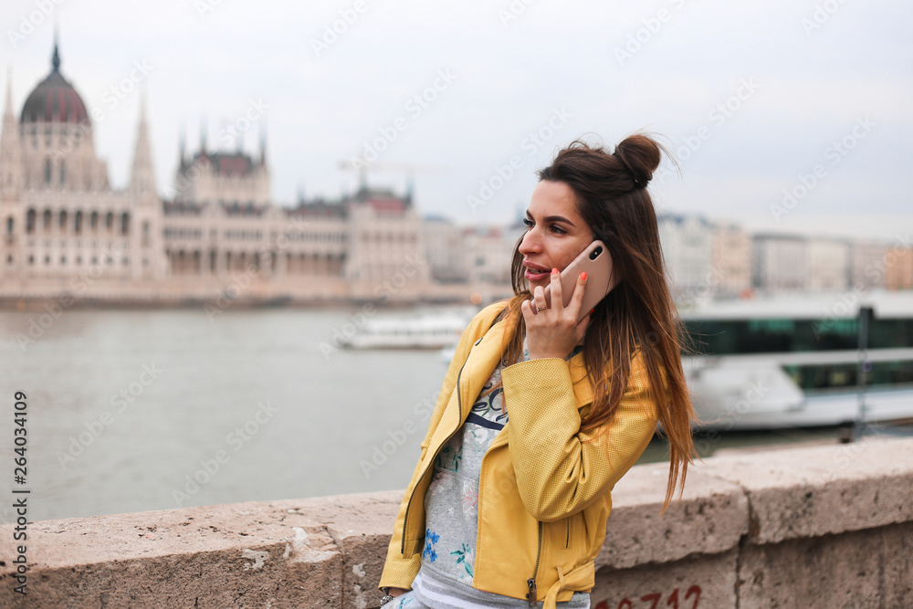 Fototapeta premium young beauty girl talk on phone on Budapest parliament background 