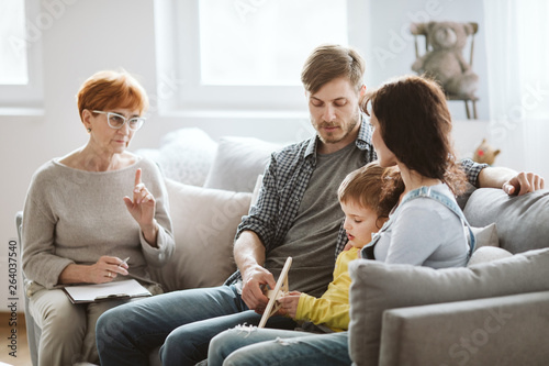 Parents and therapist are sitting on the couch during a meeting about their child