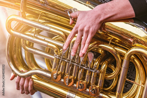 Musician playing tuba at evening time on the city square. photo