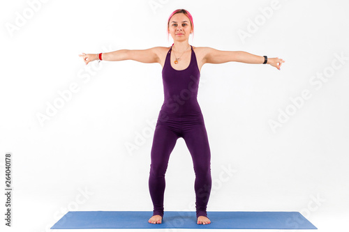 Beautiful girl standing in yoga pose on white background. Fitness trainer training showing exercises photo