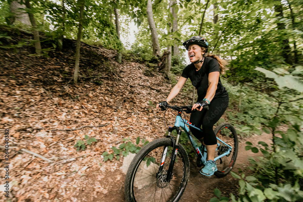 Woman Mountain bikes through Lincoln Woods State Park in Rhode Island Woman Mountain bikes through Lincoln Woods State Park in Rhode Island