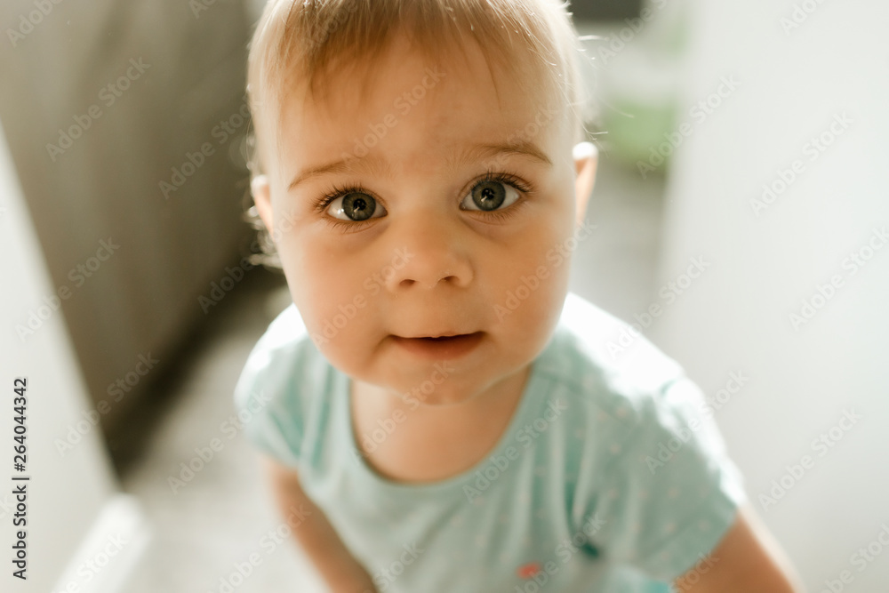 Baby girl standing in doorway slightly smiling up Baby girl standing in doorway slightly smiling up