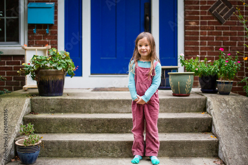 Portrait of a cute girl standing on her front stoop photo