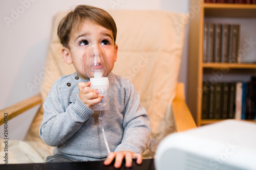 Photos Little boy using steam inhaler nebulizer mask inhalation at home