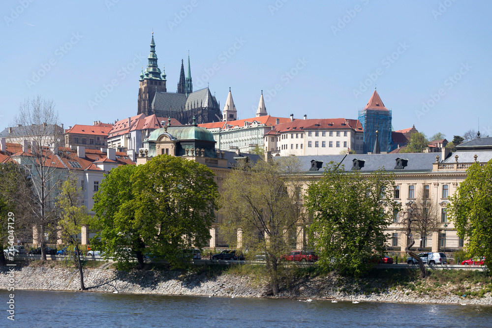 Obraz premium Spring green Prague Lesser Town with gothic Castle above River Vltava in the sunny Day, Czech Republic