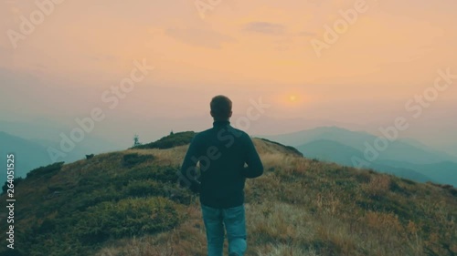 The man running on the mountain against the sunset background. slow motion photo