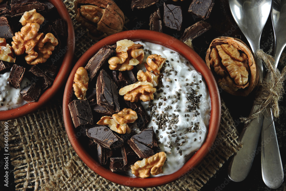 Keto breakfast or dessert. White yogurt with chia, walnuts and dark chocolate. Useful energy food. Eco food. Superfoods Keto breakfast or dessert. White yogurt with chia, walnuts and dark chocolate. Useful energy food. Eco food. Superfoods