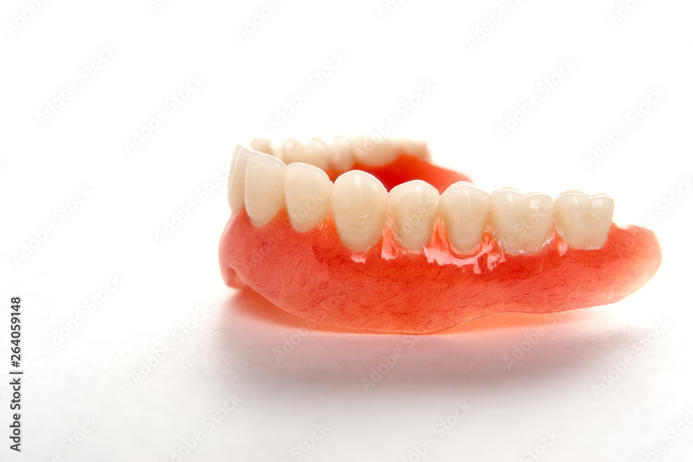 Artificial teeth on a white background with copy space, close-up Artificial teeth on a white background with copy space, close-up