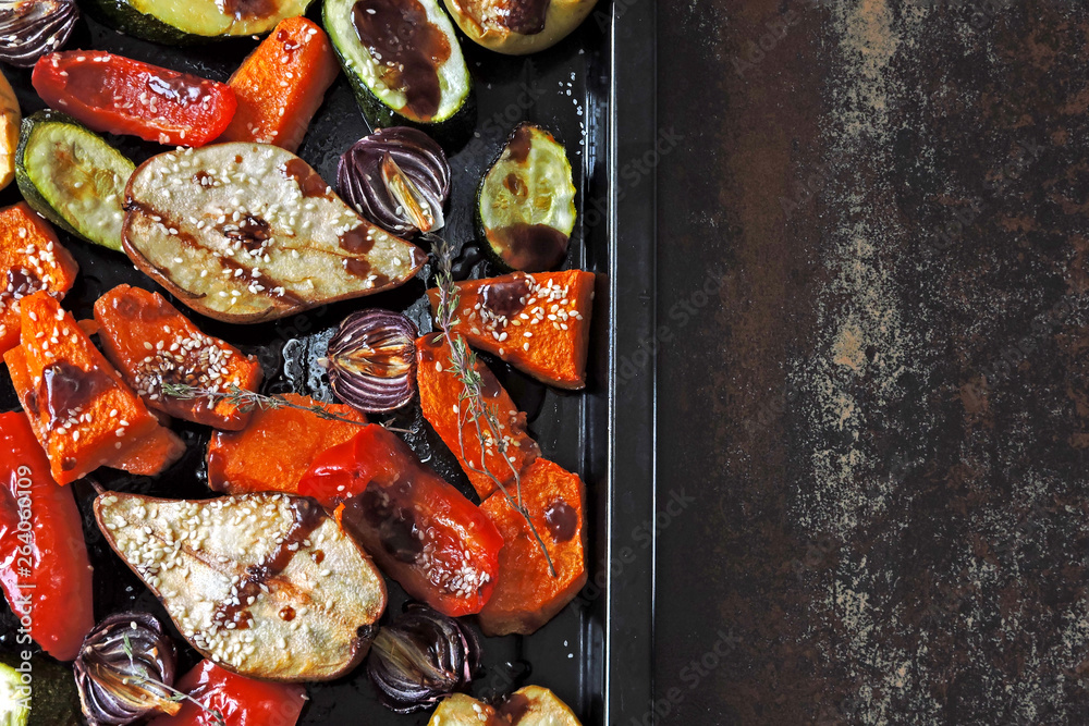 Baked vegetables and fruits on a baking sheet. Vegan theme. Appetizing baked vegetables and fruits with spices. Baked vegetables and fruits on a baking sheet. Vegan theme. Appetizing baked vegetables and fruits with spices.