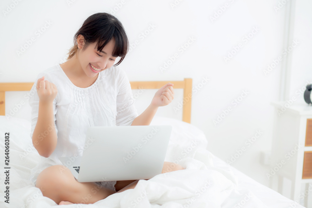 Beautiful of portrait asian young woman sitting relax and leisure with laptop computer internet online on bed in bedroom, cheerful of asia girl with gesture glad and success, lifestyle concept. Beautiful of portrait asian young woman sitting relax and leisure with laptop computer internet online on bed in bedroom, cheerful of asia girl with gesture glad and success, lifestyle concept.
