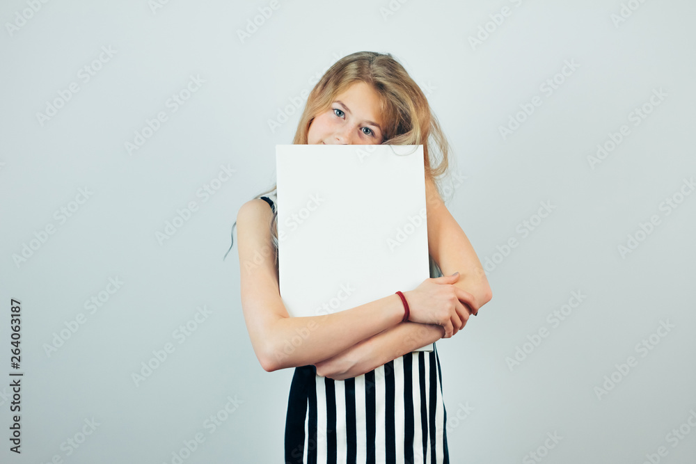 Blond teen girl embracing poster template, grey wall on background. Beautiful girl with blank empty canvas. Copy space for text on canvas board. Blond teen girl embracing poster template, grey wall on background. Beautiful girl with blank empty canvas. Copy space for text on canvas board.