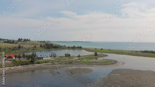 Cinematic drone / aerial static footage showing the ocean and a few chalets in Kingsburg, Nova Scotia, Canada during summer season. photo