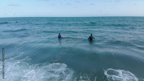 Cinematic drone / aerial static footage showing a couple of surfers at Cole Harbour coast in Lawrencetown, Nova Scotia, Canada during summer season. photo