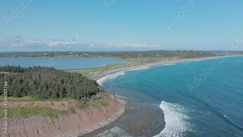 Cinematic drone / aerial footage ascending showing a forest, the beach and the ocean at Cole Harbour coast in Lawrencetown, Nova Scotia, Canada during summer season. photo