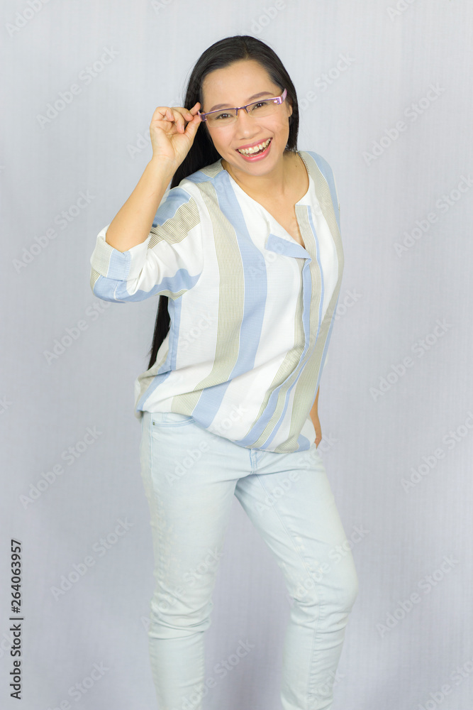 Funny Asian woman in glasses posing happy smile Isolated on gray background Funny Asian woman in glasses posing happy smile Isolated on gray background