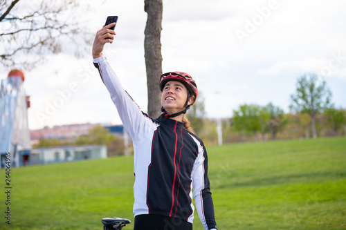 Happy cyclist taking selfie in park