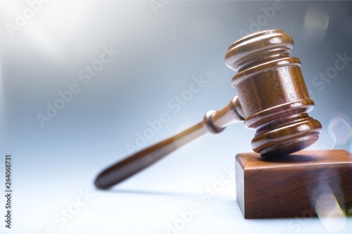 Wooden gavel on wooden table, on background